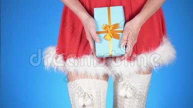 圣诞节假期。 年轻迷人的女人穿着雪<strong>少女</strong>的<strong>服装</strong>，带着礼物，在蓝色的背景上跳舞。 特写